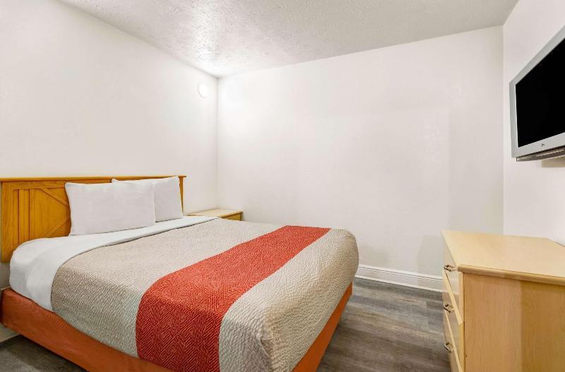 King with Jacuzzi Non-Smoking guest room with a bed, a light wood dresser and a wall-mounted TV